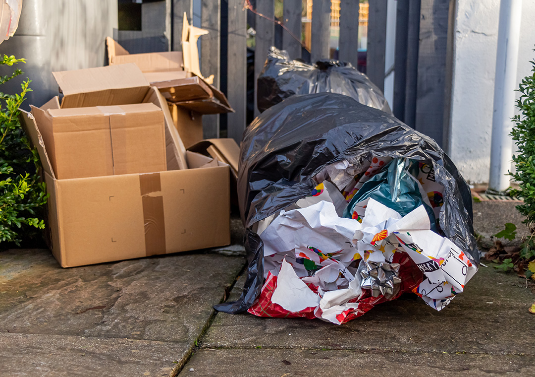 A picture of cardboard boxes and waste Christmas wrapping in a bin bag