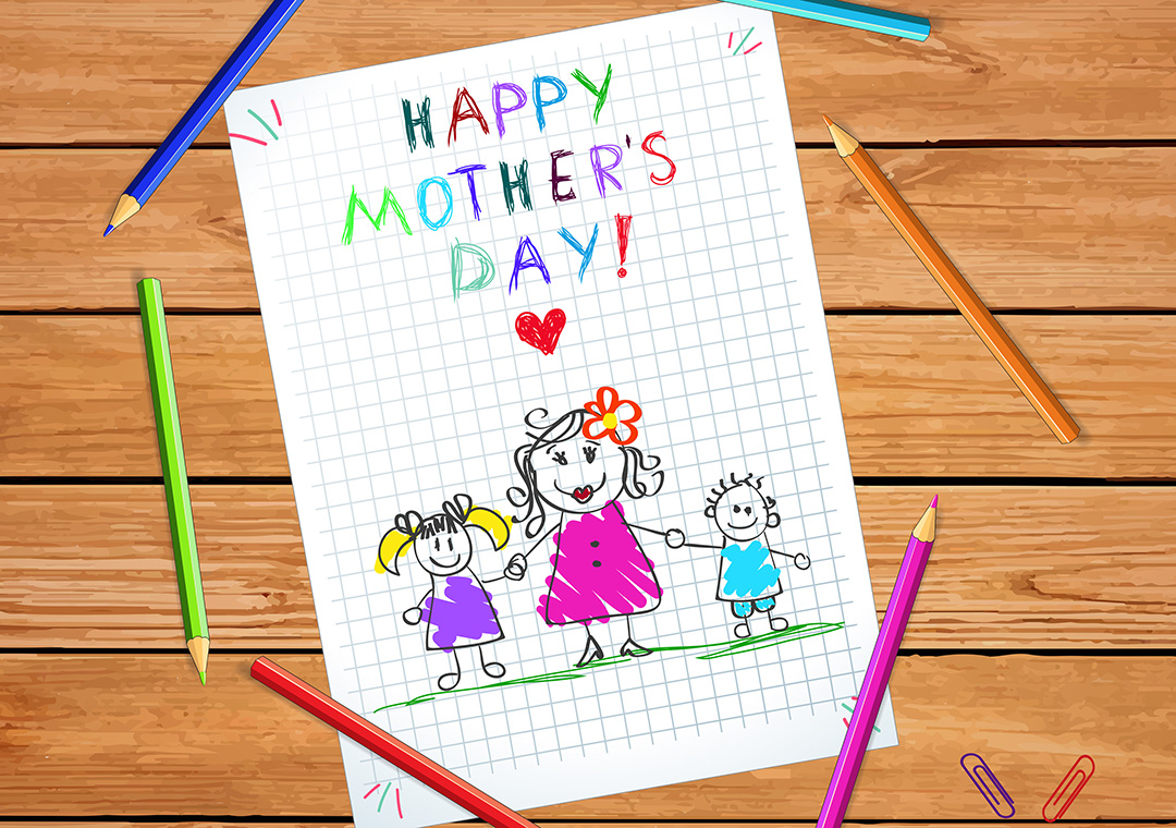 A handmade Mother's Day card with colouring pencils around it